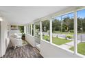 Bright screened porch with wicker furniture, wood-look flooring at 409 W Beresford Ave, Deland, FL 32720