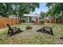 Large backyard with firepit, deck, and wooden chairs at 112 S Chandler Ave, Deland, FL 32724