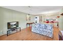 Living room with floral sofa, wood floors, and view to kitchen at 600 N Boundary Ave # 101A, Deland, FL 32720