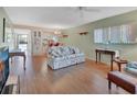 Living room with floral sofa, wood floors, and view to kitchen at 600 N Boundary Ave # 101A, Deland, FL 32720