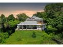 Two-story home with a large porch overlooking a lush green lawn at 2423 E New York Ave, Deland, FL 32724