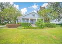 Charming light blue house with a porch and manicured lawn at 450 W Delaware Ave, Lake Helen, FL 32744