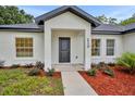 Modern front entrance with black door and red mulch landscaping at 210 E Baxter St, De Leon Springs, FL 32130