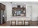 Modern kitchen with dark cabinets, quartz countertops, and island seating at 6287 Woodhaven Village Dr, Port Orange, FL 32128