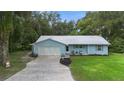 Cute blue house with a metal roof, two car garage, and large yard at 288 Silverstone Dr, Orange City, FL 32763