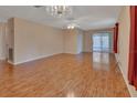 Spacious living room with hardwood floors, a chandelier, and lots of natural light at 47 Villa Villar Ct # 470, Deland, FL 32724