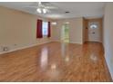 Large living room with hardwood floors and views into the kitchen and entryway at 47 Villa Villar Ct # 470, Deland, FL 32724