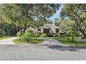 A two-story home with a long driveway, surrounded by lush trees at 1582 Covered Bridge Dr, Deland, FL 32724