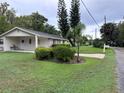 View of a single story home with a carport and landscaped yard at 1871 Riveredge Dr, Astor, FL 32102