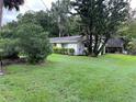 Single-story home with a large grassy yard and mature trees at 1871 Riveredge Dr, Astor, FL 32102