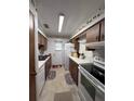 Galley-style kitchen with white appliances and wood cabinets at 1871 Riveredge Dr, Astor, FL 32102