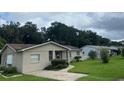 Tan single story house with a large yard and neighboring houses at 1415 Talton Ave, Deland, FL 32720