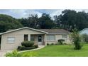 Tan single story house with a well-manicured lawn at 1415 Talton Ave, Deland, FL 32720
