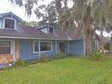 Ranch style home exterior with dark roof, stone accents, and lush landscaping at 573 Pelican Bay Dr, Daytona Beach, FL 32119