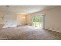 Bright living room with carpeted floors and sliding glass doors leading to backyard at 1631 Primo Ct, Holly Hill, FL 32117
