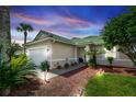 Well-maintained house with a green roof, landscaping, and a two-car garage at 399 Foxhill Dr, Debary, FL 32713