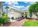 Tan house with green tile roof, palm trees, and a nicely landscaped yard at 399 Foxhill Dr, Debary, FL 32713