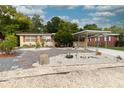 Home with a landscaped front yard featuring rock gardens and a carport at 1465 Wildrose Ln, Daytona Beach, FL 32117