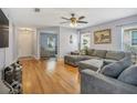 Spacious living room with hardwood floors, gray sectional sofa, and ceiling fan at 3321 Pino Ave, New Smyrna Beach, FL 32168