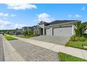 Houses with gray three-car garages, paver driveways, and landscaping at 397 Aquamarine Way, Daytona Beach, FL 32124