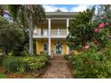 Two story yellow house with porch and landscaping at 900 Riverside Dr, Daytona Beach, FL 32117