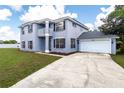 Two-story house with gray exterior, two-car garage, and large yard at 1438 Gaynor Ct, Deltona, FL 32725