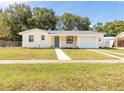 Newly renovated light yellow house with a gray door and a two car driveway at 1092 Cobblestone Ave, Deltona, FL 32725