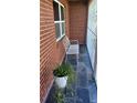 Front porch with brick wall, white metal bench, and potted plants at 1165 Anderson St, Deltona, FL 32725