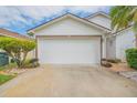 Two-car garage with white door and landscaping at 316 Dahoon Holly Dr, Daytona Beach, FL 32117