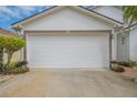 Attached garage with white door and landscaping at 316 Dahoon Holly Dr, Daytona Beach, FL 32117