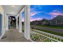Covered porch with white columns, stone flooring, and a view of the neighborhood at 53 Marden Dr, Ormond Beach, FL 32176
