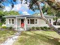 Gray house exterior with red front door and a landscaped lawn at 1109 E Arizona Ave, Deland, FL 32724