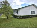 White single story home with green accents and well-manicured lawn at 201 N Hill Ave # 150, Deland, FL 32724