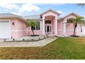 Front entrance of a pink house with columns and landscaping at 7 Sea Park Ter, Ormond Beach, FL 32176