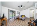 Living room features L-shaped sofa, wood-look flooring and access to screened porch at 1171 Daimler Dr, Apopka, FL 32712