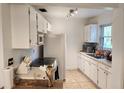 Clean kitchen featuring white cabinets and a window at 1777 Oasis Ave, Deltona, FL 32725