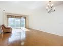 Bright living room with hardwood floors and access to a balcony at 4 Oceans West Blvd # 108B, Daytona Beach, FL 32118