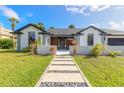Contemporary home exterior with stone walkway and lush landscaping at 6178 Knotty Pine Ct, Port Orange, FL 32127