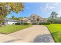 Two-story brick home with a large front yard, driveway, and mature landscaping at 6180 Knotty Pine Ct, Port Orange, FL 32127