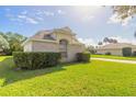 Two-story brick home with a large front yard, driveway, and mature landscaping at 6180 Knotty Pine Ct, Port Orange, FL 32127