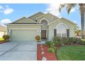 Two-story house with a green exterior, two-car garage, and landscaped front yard at 101 Marathon Ln, Sanford, FL 32771