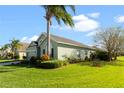 Side view of a green house showcasing landscaping and palm trees at 101 Marathon Ln, Sanford, FL 32771