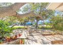 Wooden patio with metal gazebo and seating area, surrounded by trees at 75 Jennifer Cir, Ponce Inlet, FL 32127