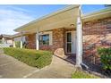 Brick home with a covered porch, white door, and landscaping at 1639 Templewood Ave, Deltona, FL 32725