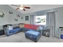 L-shaped sectional sofa, large window with view, ceiling fan, and light-colored walls at 2585 Delbarton Ave, Deltona, FL 32725