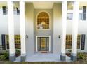Front entrance with columns, arched window, and double doors at 1907 Enterprise Osteen Rd, Deltona, FL 32738