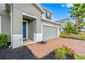 Front entry with blue door, brick walkway, and landscaping at 3404 Grassy Lake View Ave, Minneola, FL 34715