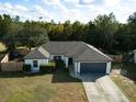 Single-story house with gray garage, fenced yard, and tree surroundings at 885 S Hancock Dr, Deltona, FL 32725