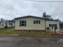 Tan mobile home with green shutters and a mailbox at 1632 Bream Dr, Seville, FL 32190