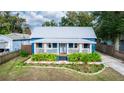 Blue cottage with a metal roof, white accents, and lush landscaping at 331 Sheldon St, New Smyrna Beach, FL 32168